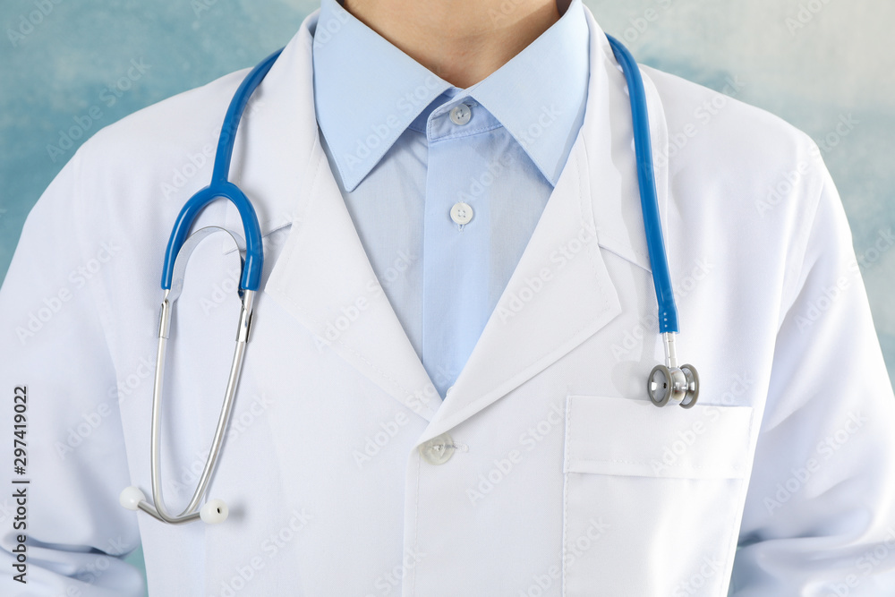 Doctor with stethoscope against blue background, close up Doctor with stethoscope against blue background, close up