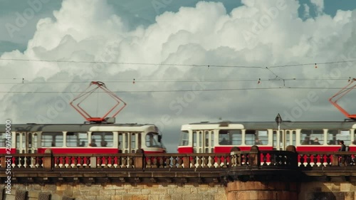 Prague, Czech Republic - September 2019: Bridge with people, tram and fluffy clouds in background. 4K resolution, shallow depth of field.