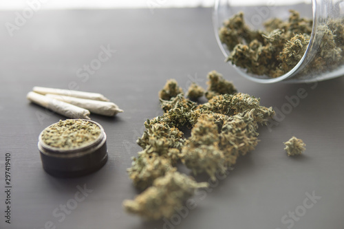 joint with weed, Cannabis buds on black table, grinder with fresh marijuana, top view close up, With light tinted