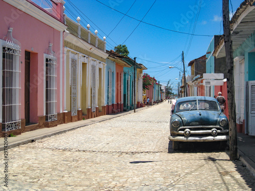 Canvas Print Old car parked in front of colorful houses on the cobblestone streets of the UNE