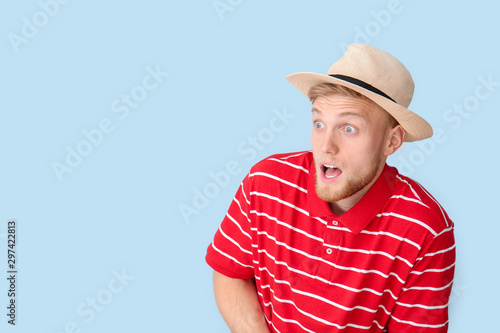 Shocked young man on color background