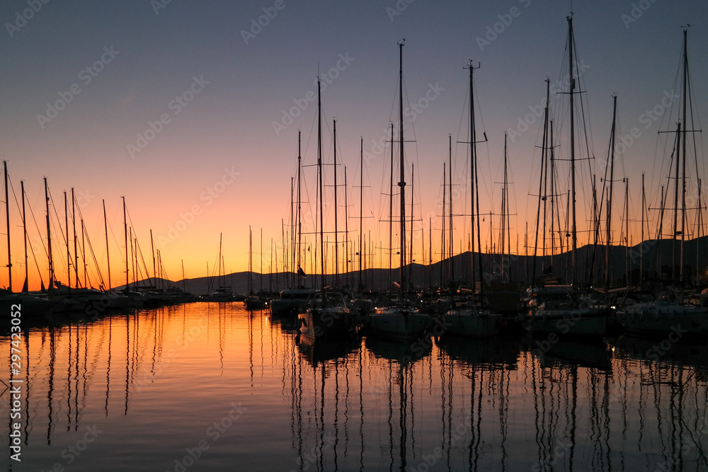Silhouettes of the sailing boats in the marina during sunset. Relaxation in sunset. Sunset view Silhouettes of the sailing boats in the marina during sunset. Relaxation in sunset. Sunset view