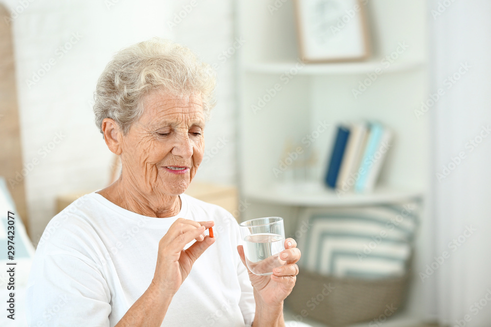 Elderly woman taking medicine at home Elderly woman taking medicine at home