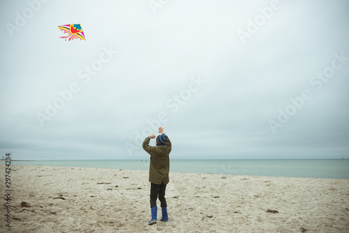 Teen brother and sister playing with kites in sand dunes of Baltic coastline