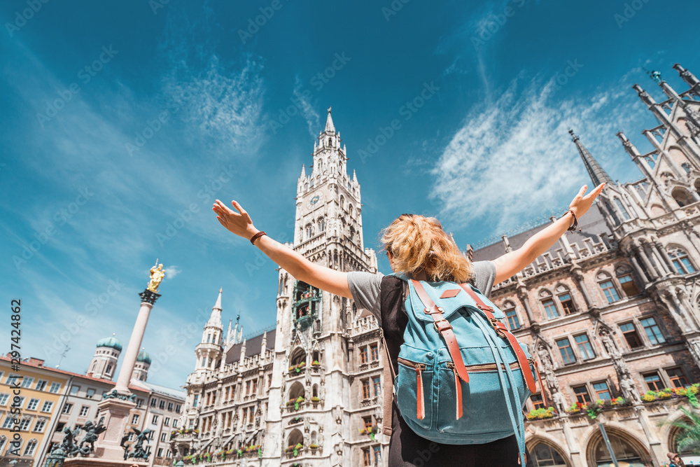 Naklejka premium Turystyczna dziewczyna cieszy się wspaniałym widokiem na gotycki budynek Starego Ratusza w Monachium. Zwiedzanie i eksploracja koncepcji Niemiec