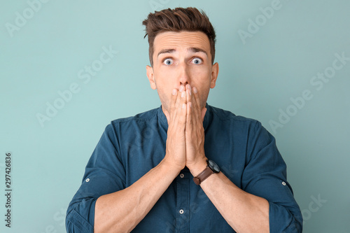 Stressed young man on color background