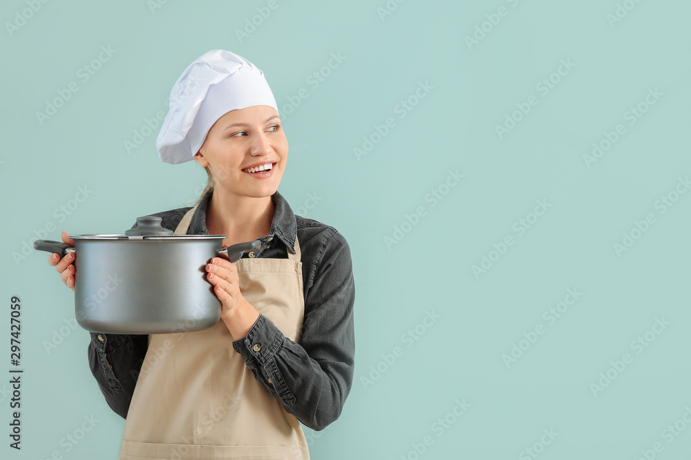 Beautiful female chef with saucepan on color background Beautiful female chef with saucepan on color background