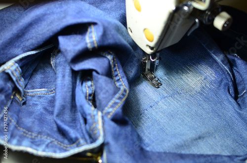 фотографія Stitching, stitching a hole in blue jeans with a sewing machine
