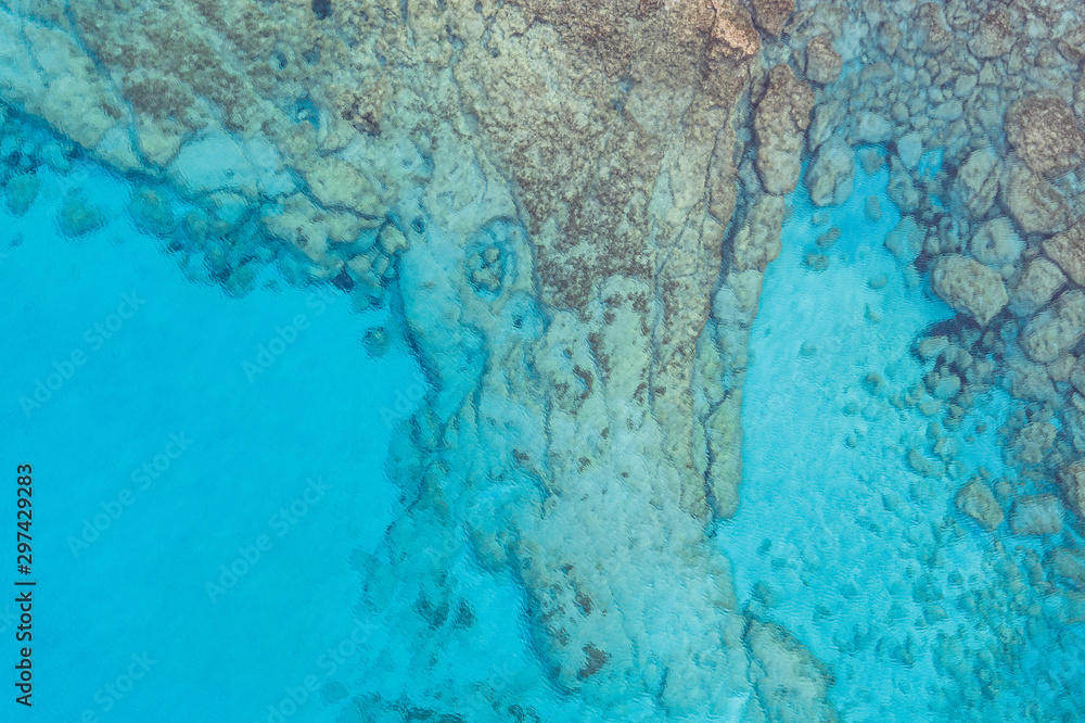 An aerial view of the beautiful Mediterranean sea, where you can se the rocky textured underwater corals and the clean turquoise water of blue lagoon Agia Napa