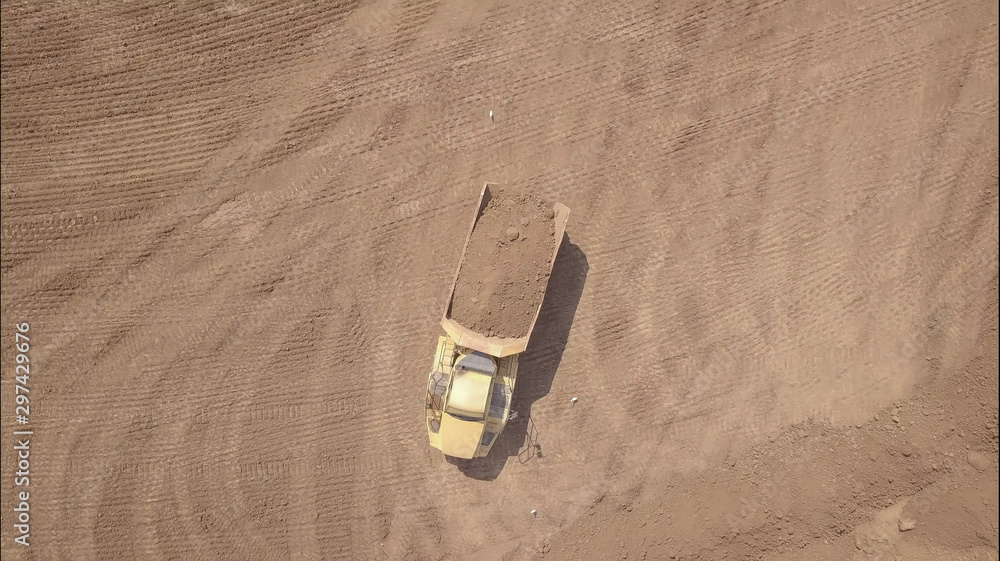 Dump truck transporting sand and soil on a new construction site. Aerial view. Dump truck transporting sand and soil on a new construction site. Aerial view.