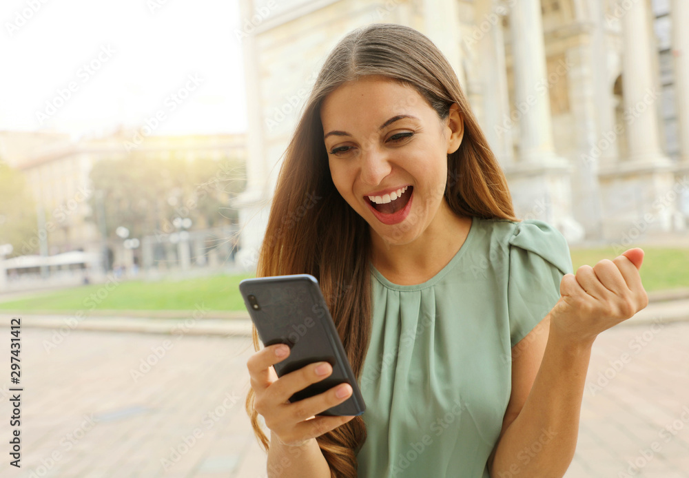 Euphoric cheerful woman checking her smart phone in city square. Euphoric cheerful woman checking her smart phone in city square.