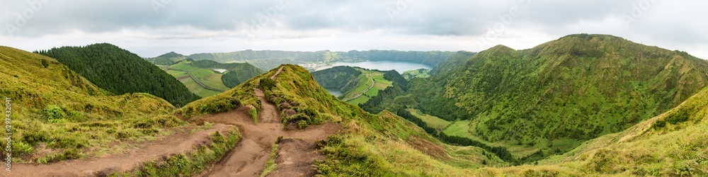 Panoramic view from the Miradouro da Grota do Inferno viewpoint at Sete Cidades on São Miguel in the Azores. The Lagoa Azul is in the background with a mud dirt footpath leading towards the distance.