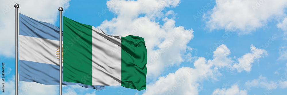 Argentina and Nigeria flag waving in the wind against white cloudy blue sky together. Diplomacy concept, international relations.