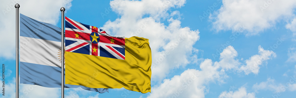 Argentina and Niue flag waving in the wind against white cloudy blue sky together. Diplomacy concept, international relations. Argentina and Niue flag waving in the wind against white cloudy blue sky together. Diplomacy concept, international relations.