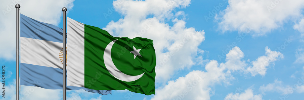 Argentina and Pakistan flag waving in the wind against white cloudy blue sky together. Diplomacy concept, international relations. Argentina and Pakistan flag waving in the wind against white cloudy blue sky together. Diplomacy concept, international relations.