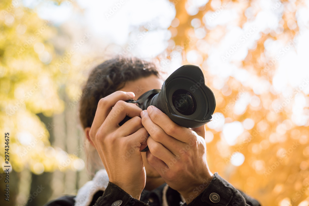 Young photographer taking pictures of nature in city park, admire the beauty of nature Young photographer taking pictures of nature in city park, admire the beauty of nature