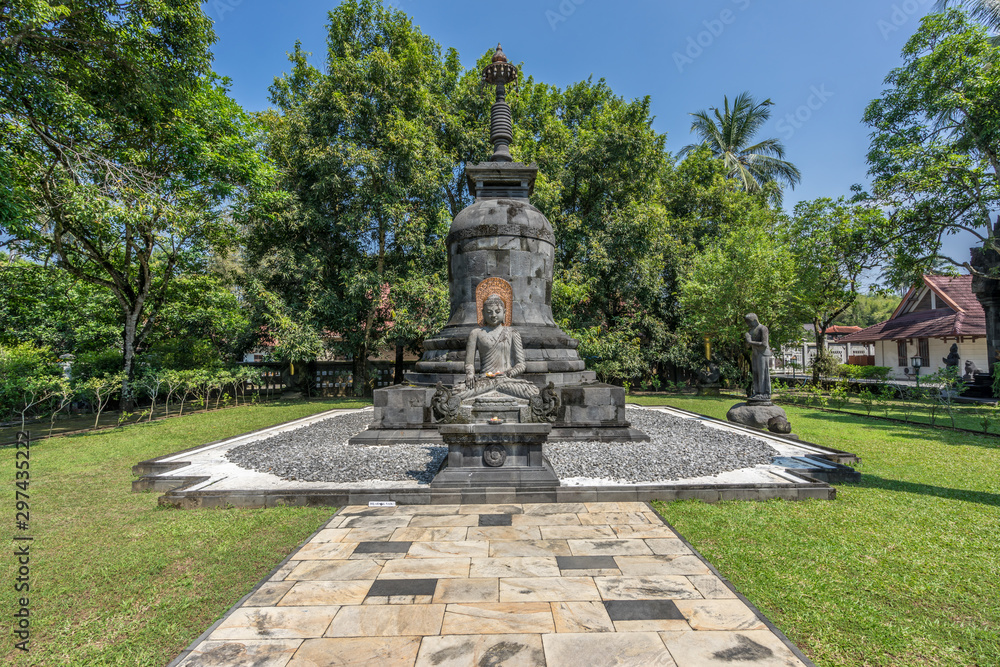 Buddha stone statue in the Bhumisparsha Mudra or gesture. Mendut Buddhist Monastery (Vihara Mendut). Located next to Mendut Temple, Mungkid Town, Central Java.
