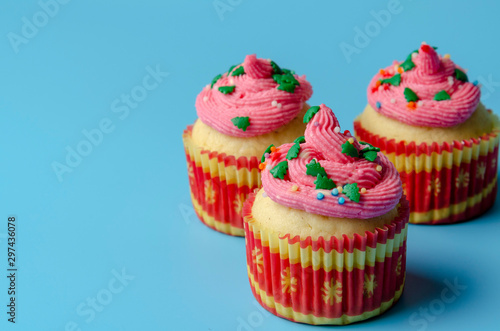 Christmas cupcake on blue background with copy space