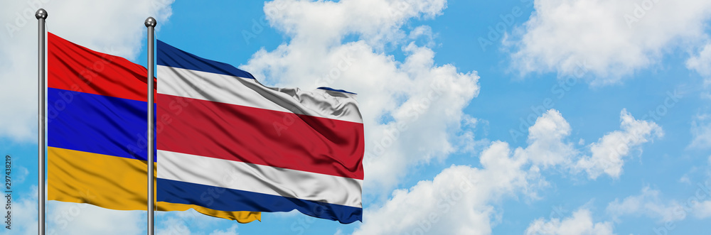 Naklejka premium Armenia and Costa Rica flag waving in the wind against white cloudy blue sky together. Diplomacy concept, international relations.