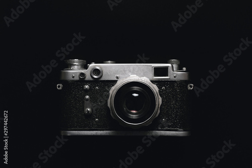 Vintage photo camera in darkness background, close up