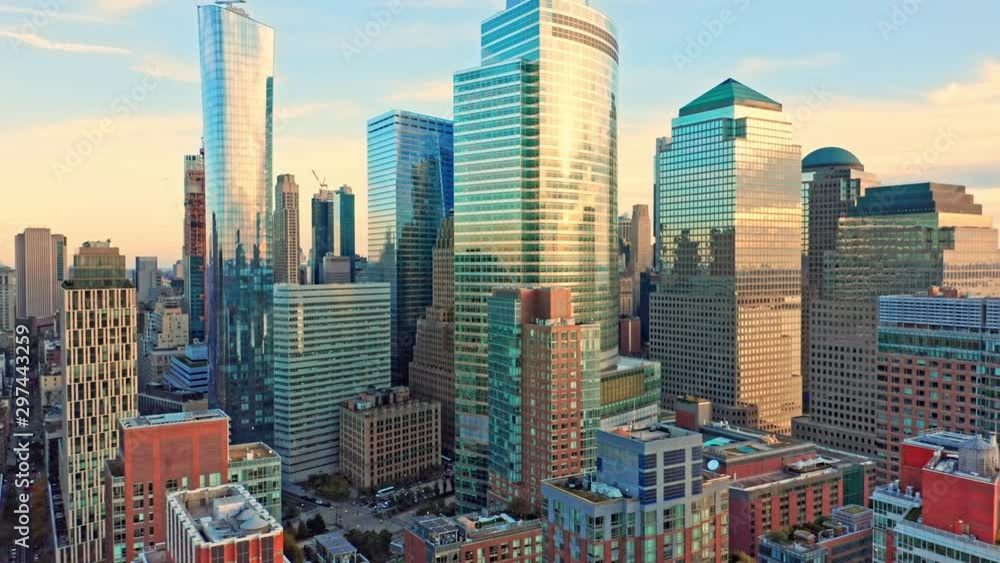Drone footage with slow pull back away from New York City Lower Manhattan skyscrapers on a sunny afternoon before sunset