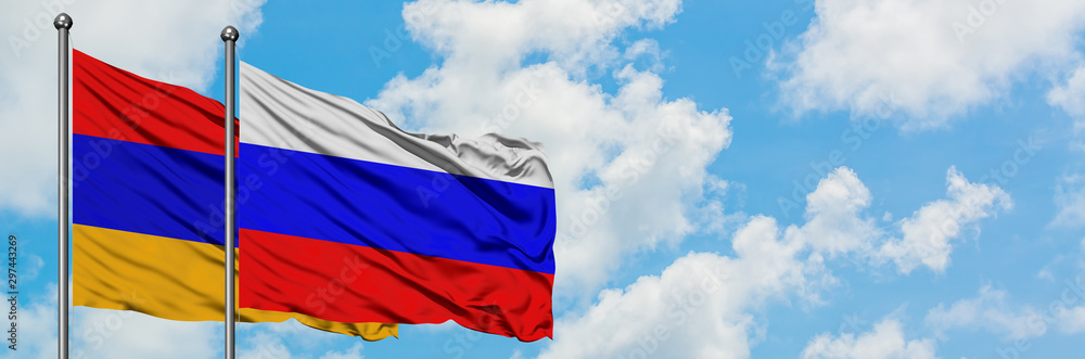 Naklejka premium Armenia and Russia flag waving in the wind against white cloudy blue sky together. Diplomacy concept, international relations.