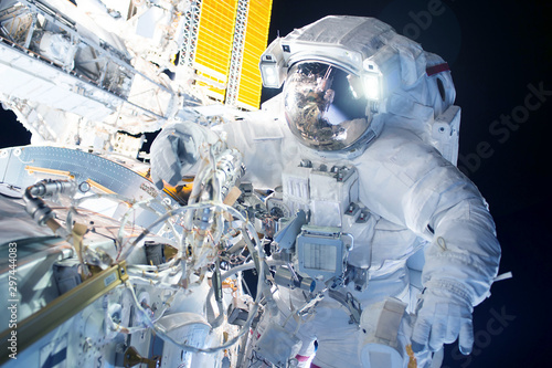 Fototapeta Naklejka Na Ścianę i Meble -  Astronaut at the space station is engaged in repairs. Elements of this image were furnished by NASA.