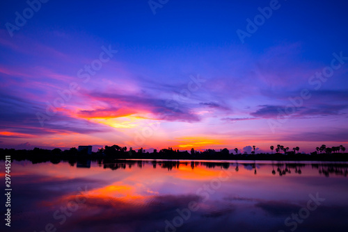 Panorama Reflection of vivid sunset sky reflection in water.Colorful sunrise with Clouds over Lake.