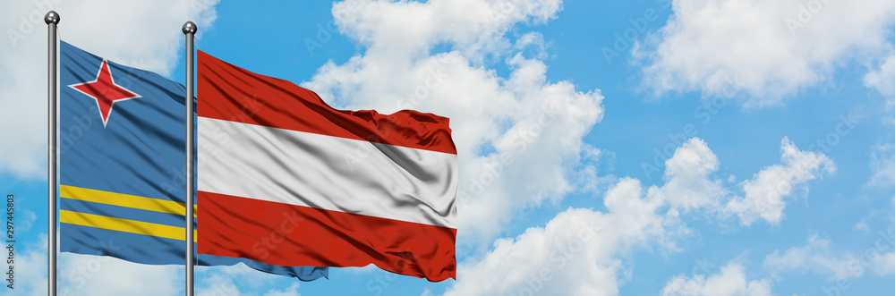 Fototapeta premium Aruba and Austria flag waving in the wind against white cloudy blue sky together. Diplomacy concept, international relations.