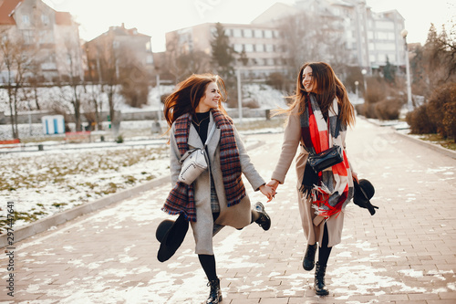 Fashionable girls in a winter city. Stylish ladies in a coats