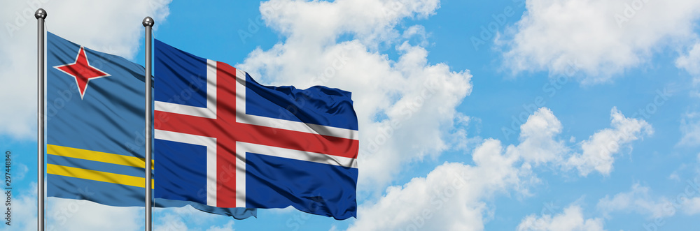 Aruba and Iceland flag waving in the wind against white cloudy blue sky together. Diplomacy concept, international relations. Aruba and Iceland flag waving in the wind against white cloudy blue sky together. Diplomacy concept, international relations.