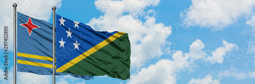 Aruba and Solomon Islands flag waving in the wind against white cloudy blue sky together. Diplomacy concept, international relations.