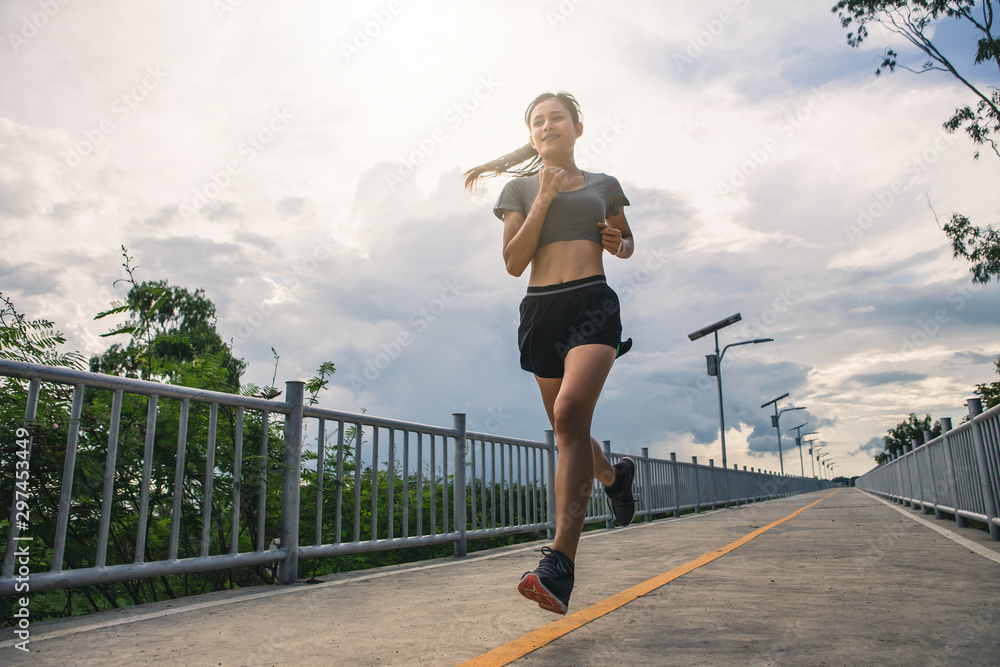 Young woman running in the nature. Healthy lifestyle and sport concepts.  Runner training in a urban area.The woman with runner on the street be running for exercise.