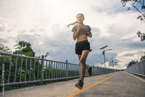 Young woman running in the nature. Healthy lifestyle and sport concepts. Runner training in a urban area.The woman with runner on the street be running for exercise.