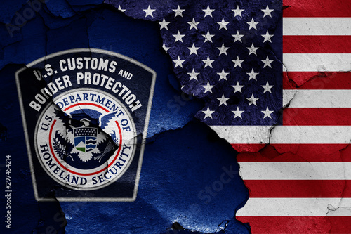 flags of U.S. Customs and Border Protection and USA painted on cracked wall photo