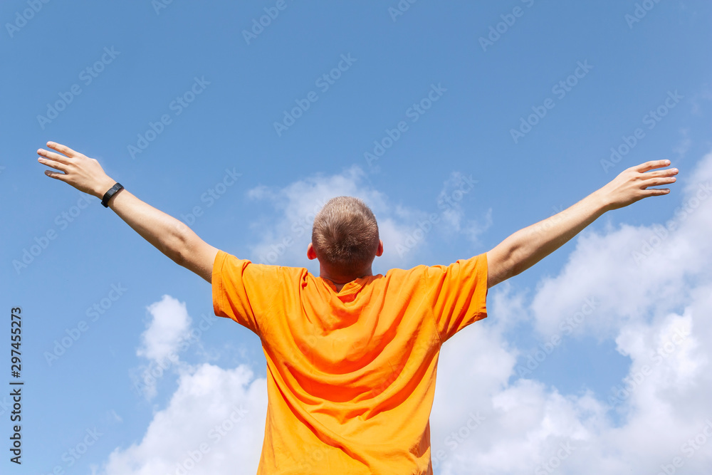 The guy stands with his arms outstretched to the sky The guy stands with his arms outstretched to the sky