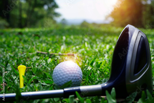 Blurred golf club and golf ball close up in grass field with sunset. Golf ball close up in golf coures at Thailand