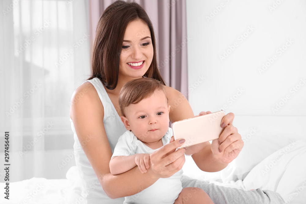 Happy young mother with her cute little baby taking selfie in bedroom Happy young mother with her cute little baby taking selfie in bedroom