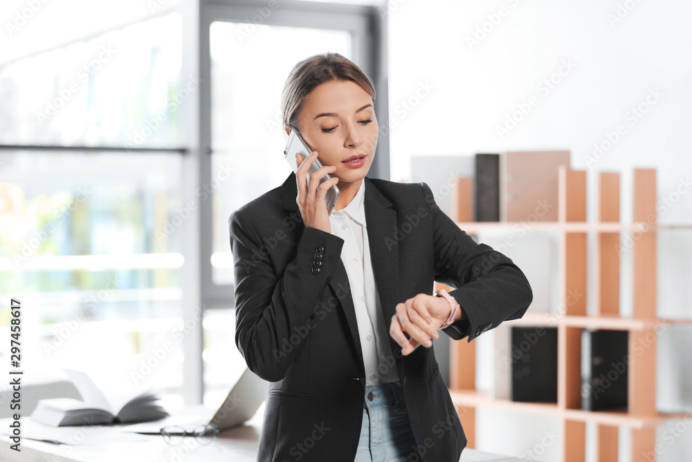Female business trainer talking on phone in office Female business trainer talking on phone in office