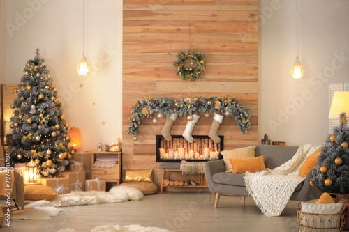 Stylish room interior with beautiful Christmas tree and decorative fireplace