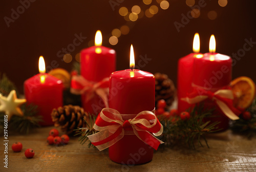 Beautiful Christmas composition with burning candle on wooden table against blurred lights