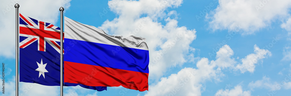 Fototapeta premium Australia and Russia flag waving in the wind against white cloudy blue sky together. Diplomacy concept, international relations.
