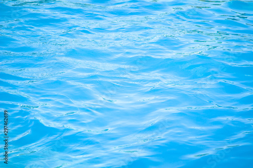 Surface of blue swimming pool background of water in swimming pool. Simulate natural wave ocean water texture summer or abstract blue sea water with white foam for copy space, nature concept.