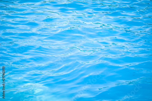 Surface of blue swimming pool background of water in swimming pool. Simulate natural wave ocean water texture summer or abstract blue sea water with white foam for copy space, nature concept.