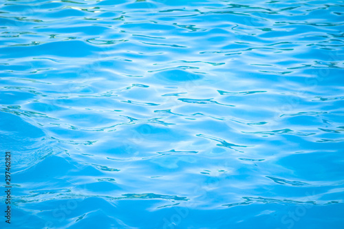 Surface of blue swimming pool background of water in swimming pool. Simulate natural wave ocean water texture summer or abstract blue sea water with white foam for copy space, nature concept. © Phokin