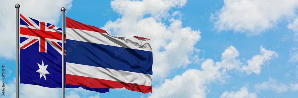 Australia and Thailand flag waving in the wind against white cloudy blue sky together. Diplomacy concept, international relations. Australia and Thailand flag waving in the wind against white cloudy blue sky together. Diplomacy concept, international relations.