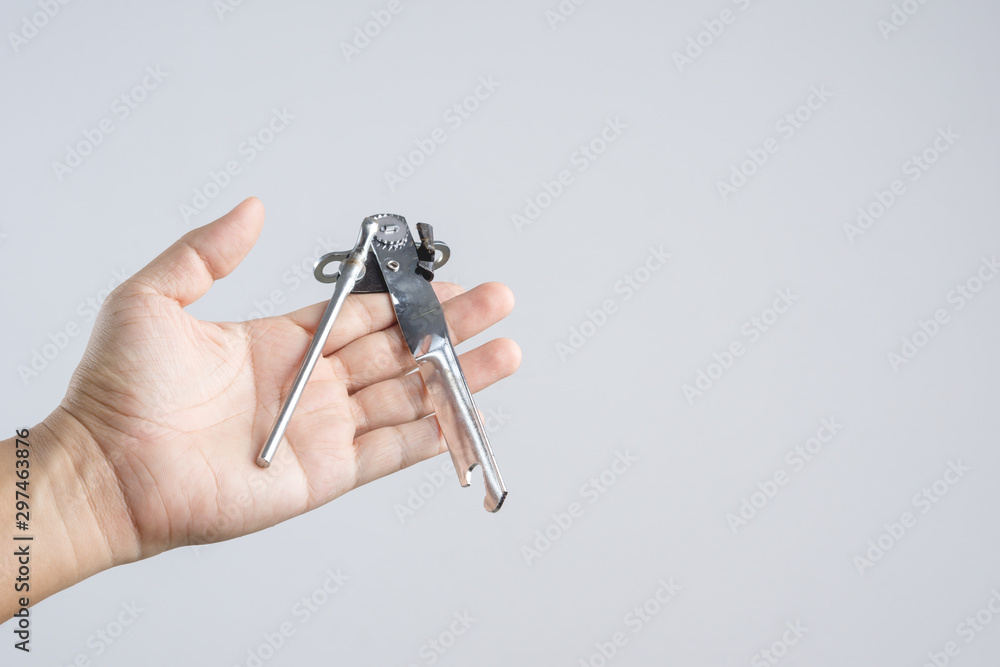 Hand holding kitchen classic can opener Hand holding kitchen classic can opener