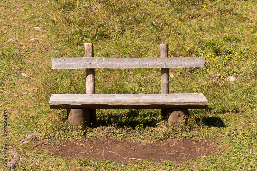 An old wooden bench in a forest clearing. An old wooden bench in a forest clearing.