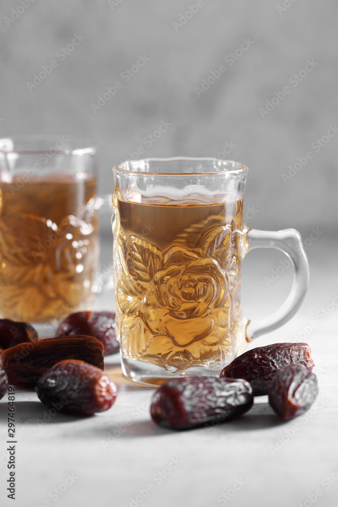dates fruit juice in mini glass on a white concrete background with a blank space for a text, dates fruit juice on a white background dates fruit juice in mini glass on a white concrete background with a blank space for a text, dates fruit juice on a white background