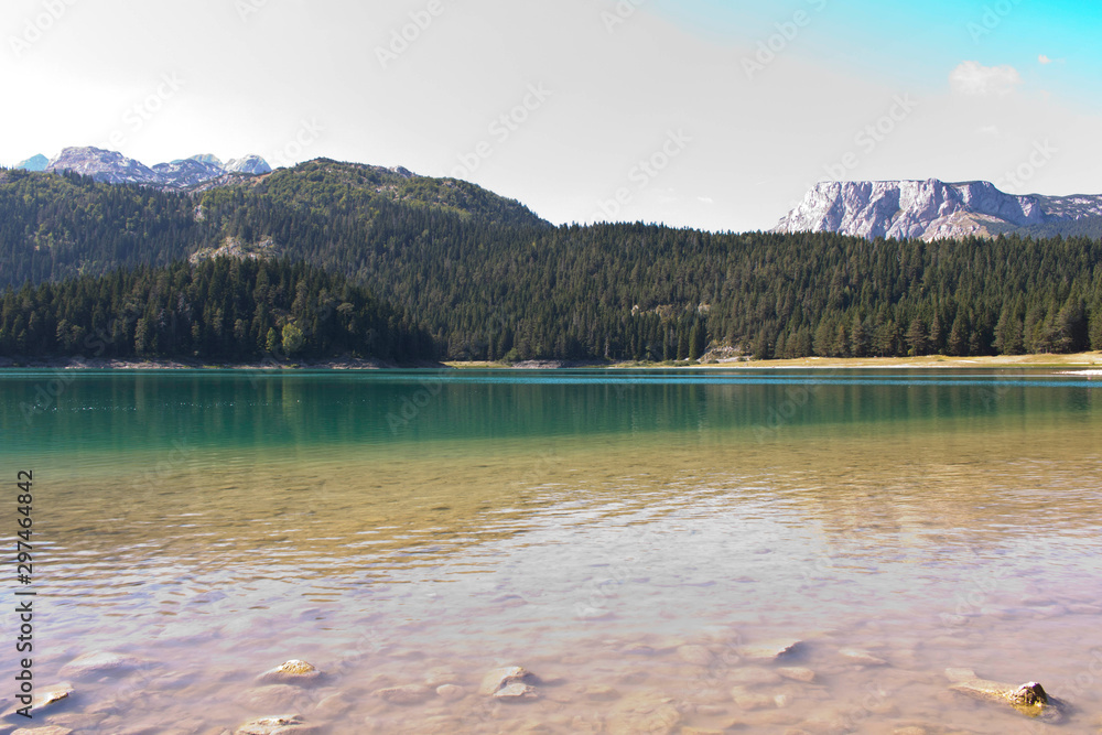 Black lake in Montenegro. Beautiful lake on the background of forest and mountains. Black lake in Montenegro. Beautiful lake on the background of forest and mountains.